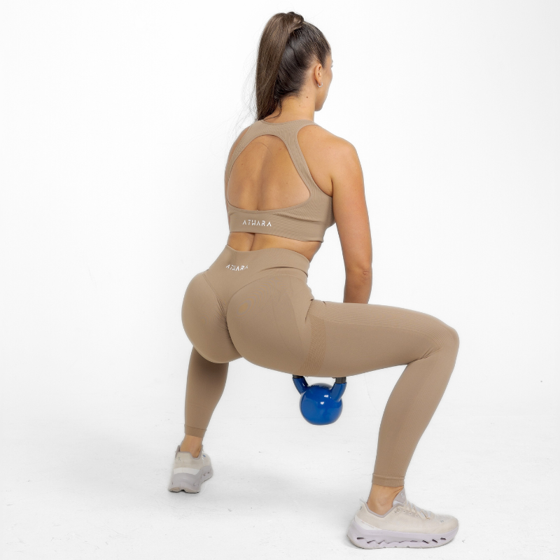 Athara MaxSculpt Leggings in Desert Tan – Model Squatting for Stretch Test