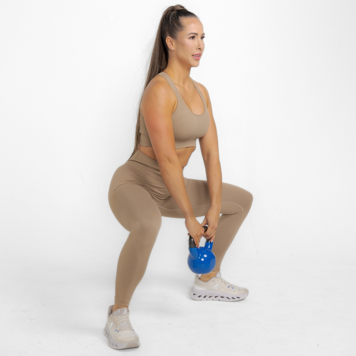 Athara MaxSculpt Leggings in Desert Tan – Model Squatting for Stretch Test